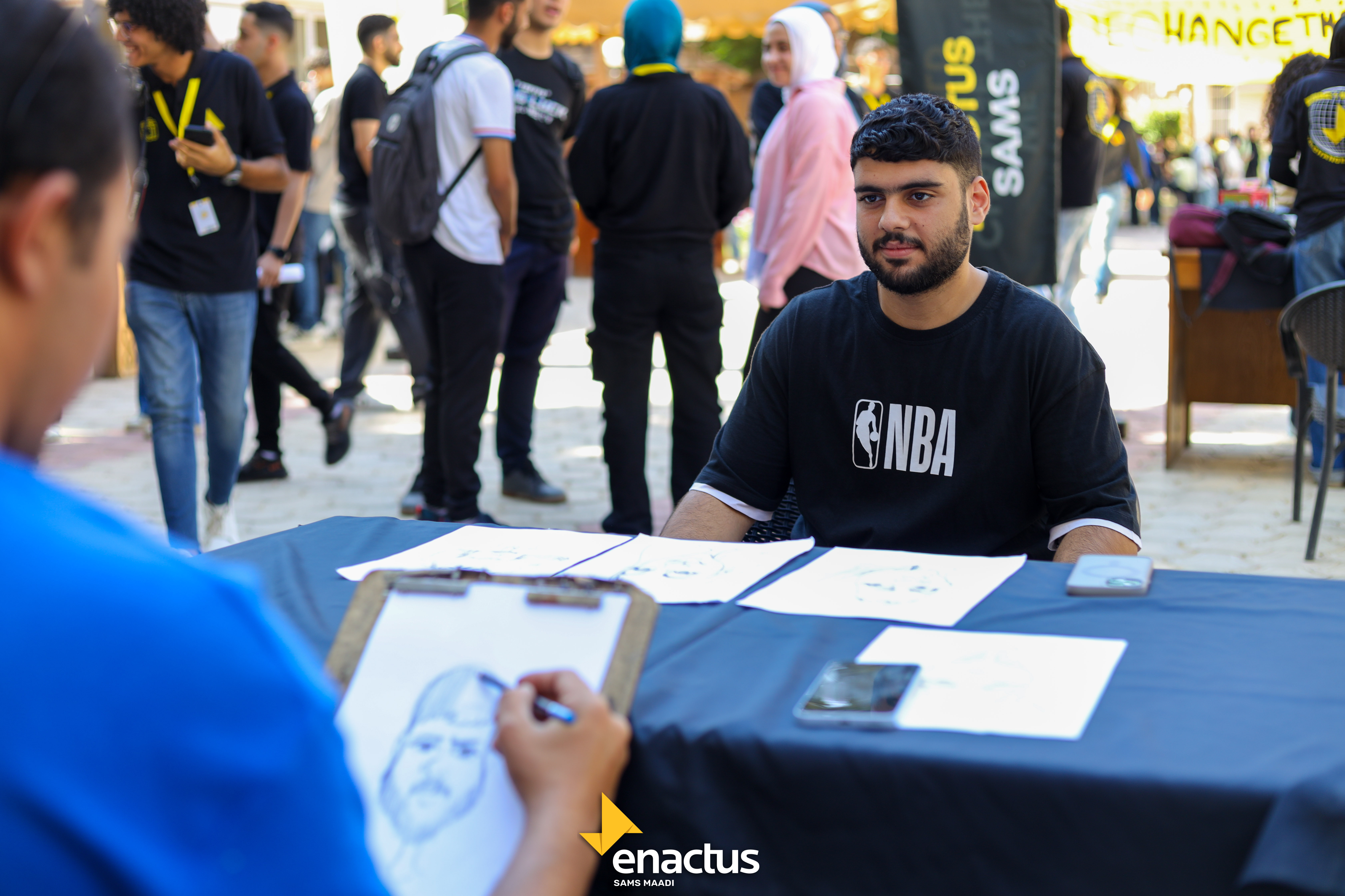 A student sitting for his caricature