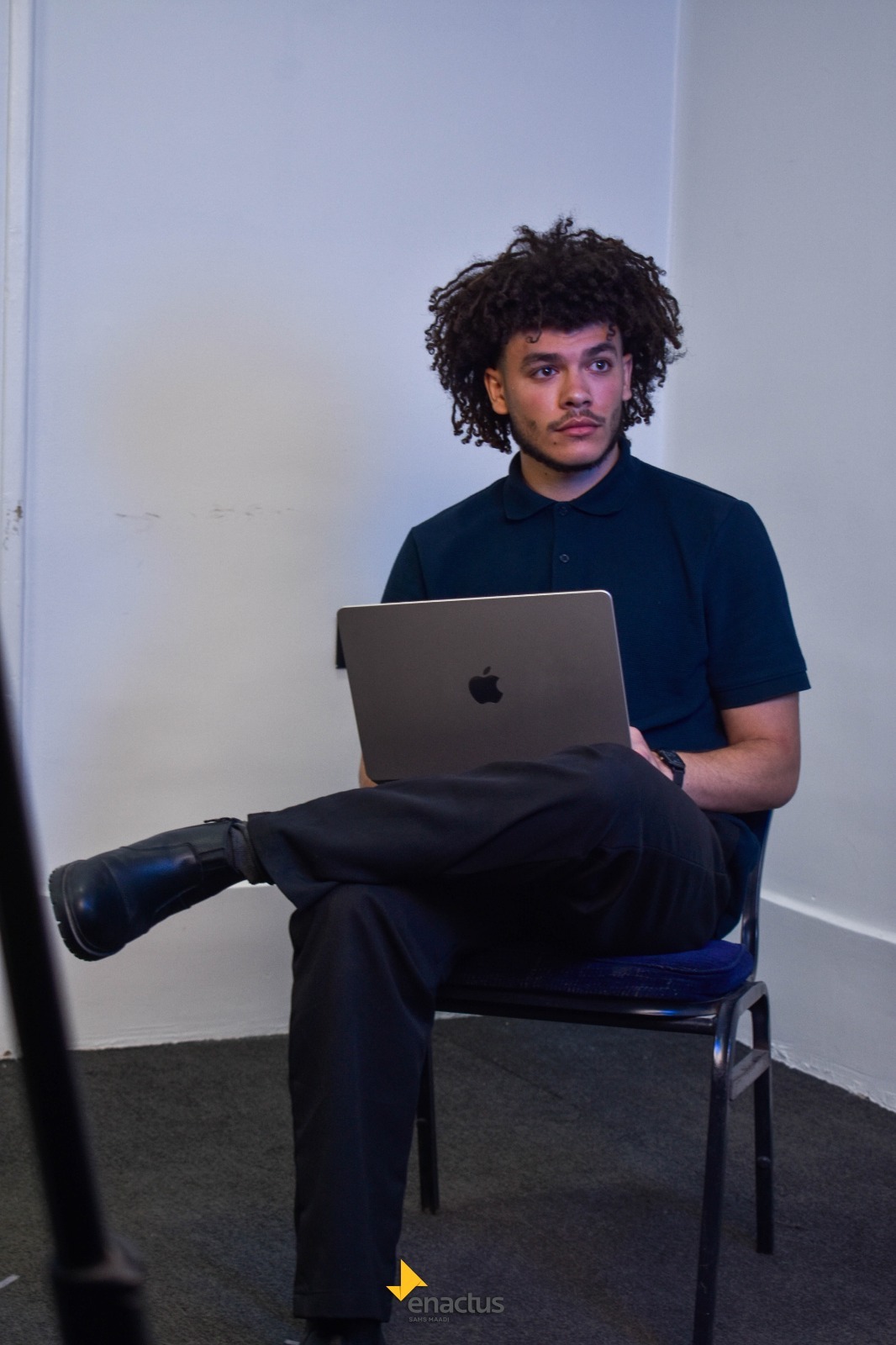 Member working on a laptop between takes